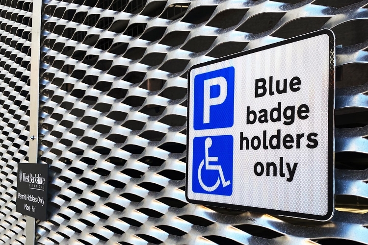 A photograph of a Blue Badge parking space sign on the wall of a car park