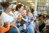 Families with babies at a rhyme time event in a library.